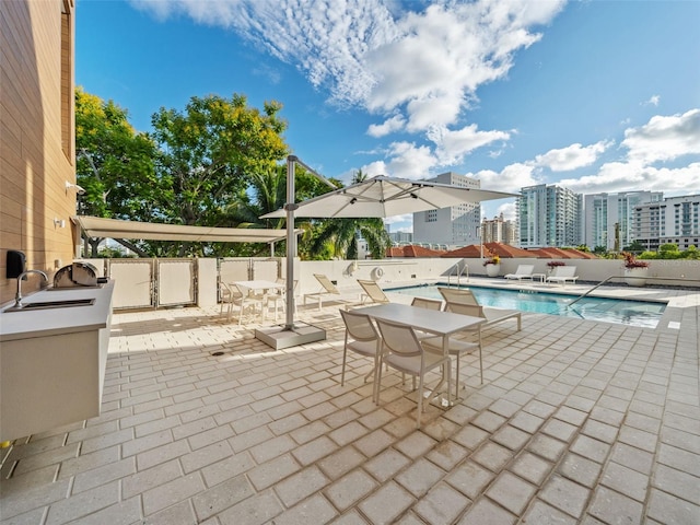 view of patio / terrace with a community pool and exterior kitchen