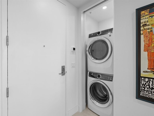 clothes washing area with stacked washer / dryer