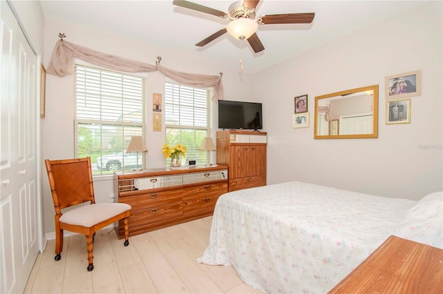 bedroom with ceiling fan, a closet, and light hardwood / wood-style flooring