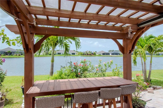 view of patio with a pergola and a water view