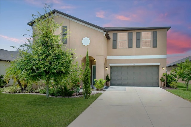 view of front facade with a garage and a lawn