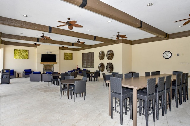 dining room with a large fireplace and beamed ceiling