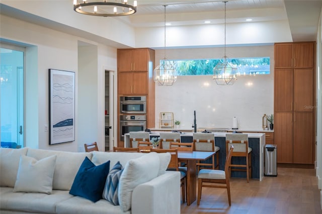 living room featuring beamed ceiling, hardwood / wood-style floors, and a chandelier