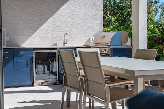 view of patio / terrace with an outdoor kitchen, a grill, sink, and beverage cooler