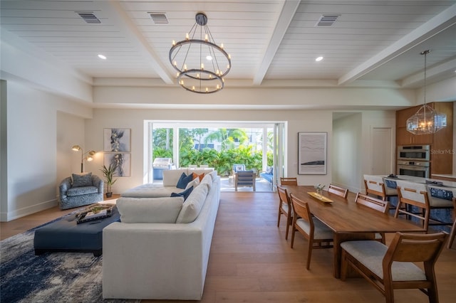 living room featuring beam ceiling, hardwood / wood-style floors, and a chandelier