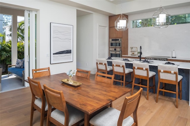 dining space featuring sink and light hardwood / wood-style floors