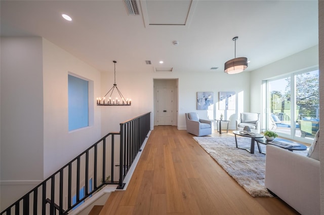 corridor featuring a chandelier and light hardwood / wood-style flooring