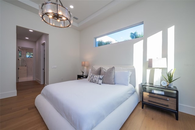 bedroom with a chandelier and hardwood / wood-style floors