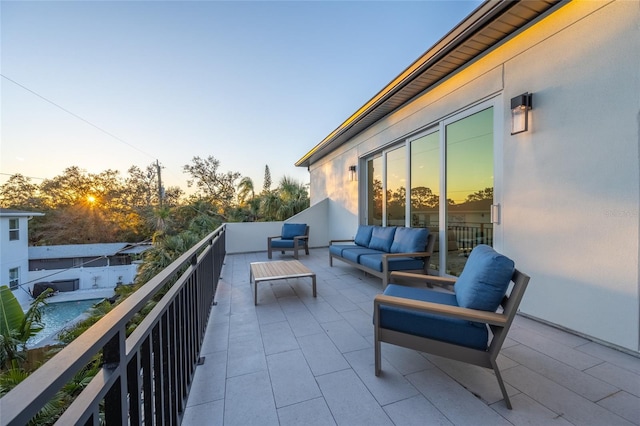 balcony at dusk featuring an outdoor hangout area