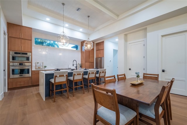 dining space featuring beamed ceiling and light hardwood / wood-style flooring