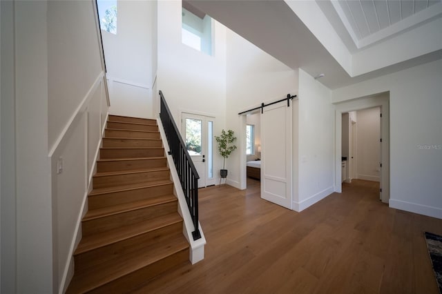 stairs featuring hardwood / wood-style floors and a barn door