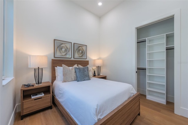 bedroom with light hardwood / wood-style floors and a closet