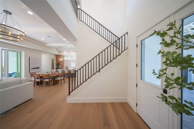 entryway featuring a wealth of natural light, a notable chandelier, and light wood-type flooring