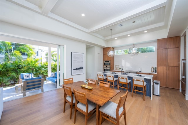 dining area featuring light hardwood / wood-style flooring and beamed ceiling