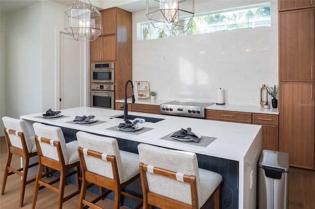 kitchen with sink, gas stovetop, wood-type flooring, decorative backsplash, and decorative light fixtures