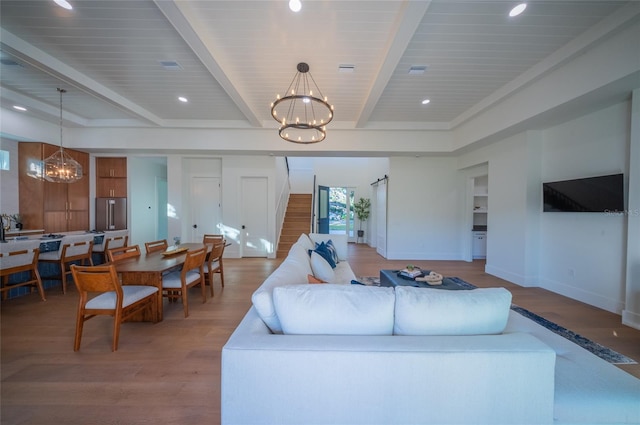 living room with hardwood / wood-style flooring, an inviting chandelier, and beamed ceiling