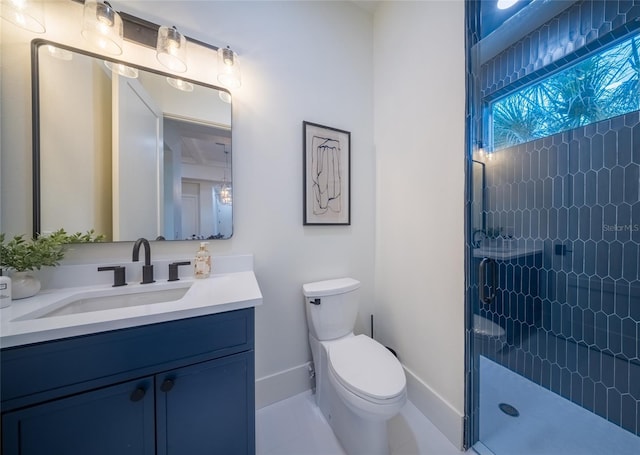 bathroom with toilet, vanity, and a shower with shower door