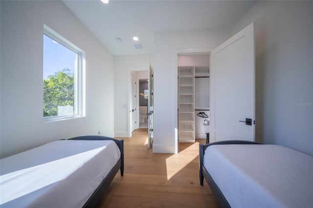 bedroom featuring a spacious closet, light hardwood / wood-style flooring, and a closet