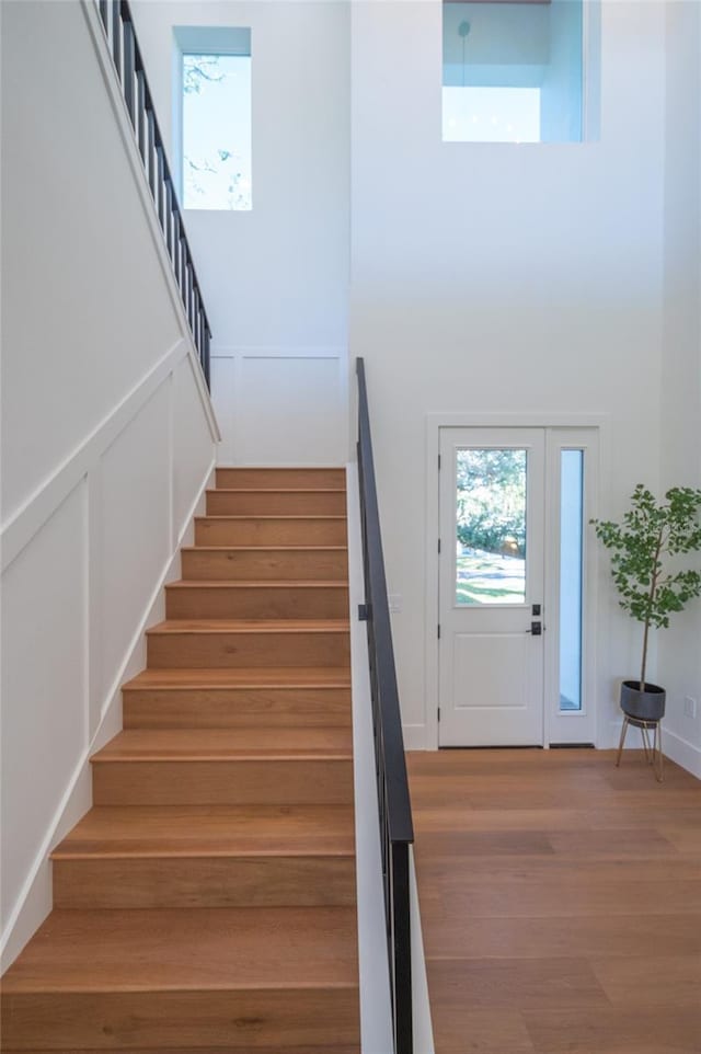 staircase featuring hardwood / wood-style flooring and a towering ceiling