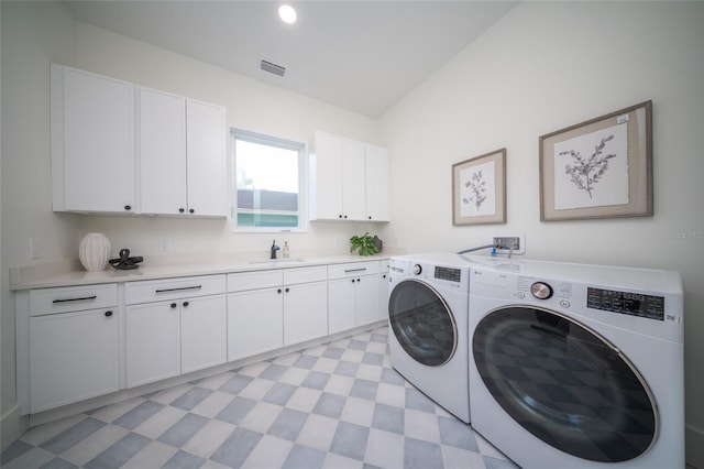 washroom featuring cabinets, sink, and washer and dryer