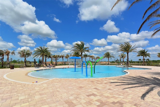 view of swimming pool featuring pool water feature and a patio