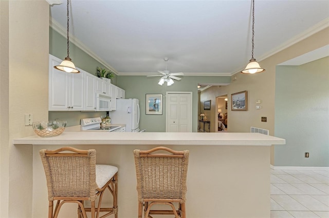 kitchen featuring kitchen peninsula, white appliances, and a breakfast bar