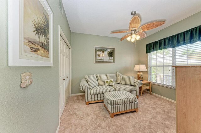 sitting room featuring ceiling fan and light colored carpet