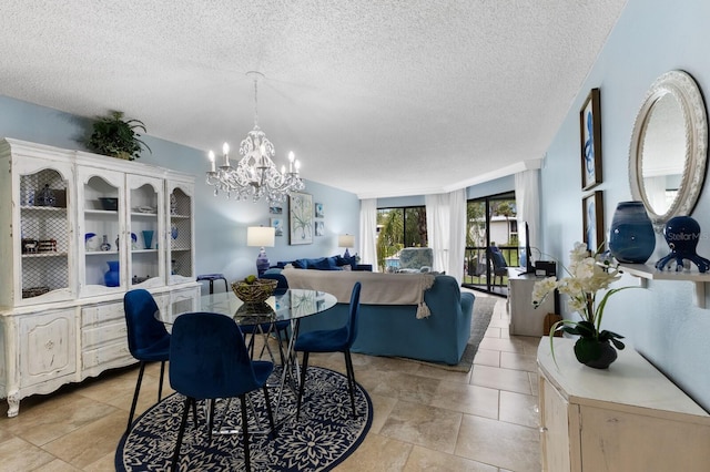 dining area with a textured ceiling and an inviting chandelier