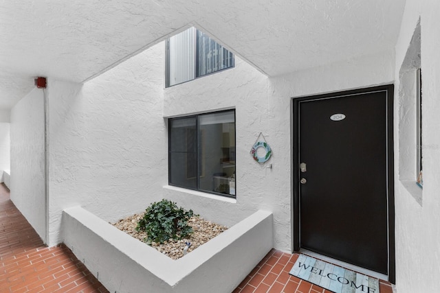 doorway to property featuring stucco siding