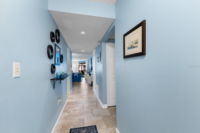 hallway featuring recessed lighting and baseboards