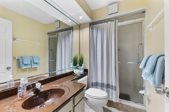 bathroom featuring toilet, recessed lighting, visible vents, vanity, and a stall shower