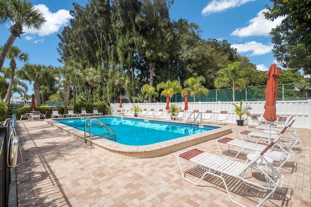 community pool with fence and a patio