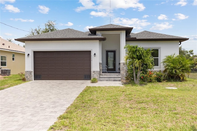 prairie-style home with a garage, central AC, and a front yard