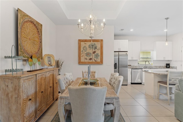 tiled dining space with an inviting chandelier, sink, and a raised ceiling