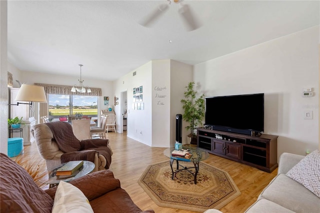 living room with ceiling fan with notable chandelier and light wood-type flooring