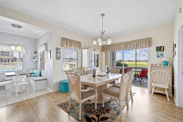 dining space featuring light hardwood / wood-style floors and a notable chandelier