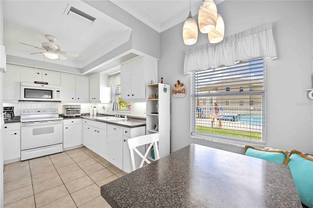 kitchen featuring pendant lighting, white appliances, white cabinets, sink, and light tile patterned floors