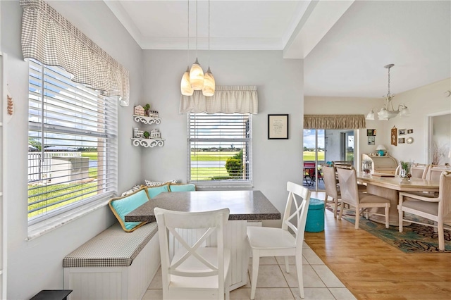 tiled dining space featuring crown molding, breakfast area, plenty of natural light, and an inviting chandelier