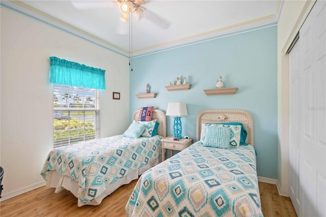 bedroom with ceiling fan, a closet, light hardwood / wood-style floors, and ornamental molding