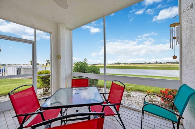 sunroom featuring a water view