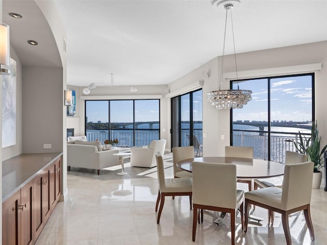 dining space featuring a notable chandelier and a water view