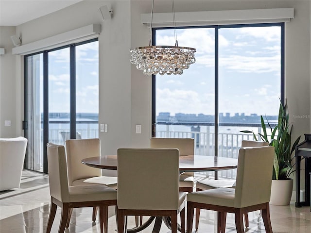 dining area featuring a chandelier and a water view