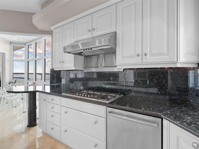 kitchen featuring decorative backsplash, white cabinets, light tile patterned floors, and appliances with stainless steel finishes