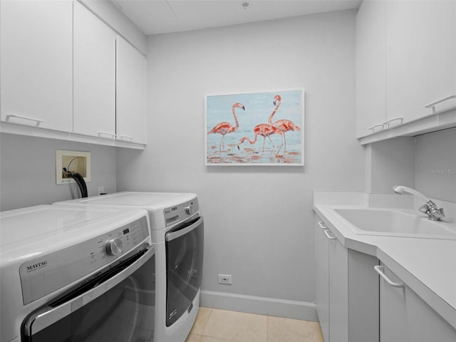 laundry area with cabinets, independent washer and dryer, light tile patterned floors, and sink