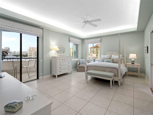 tiled bedroom featuring ceiling fan, a raised ceiling, and access to outside