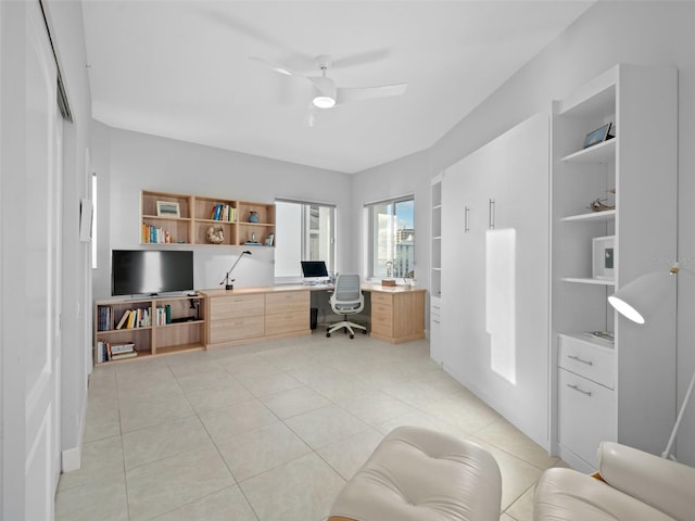 office featuring ceiling fan, light tile patterned flooring, and built in desk