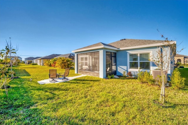 back of property featuring a sunroom and a yard