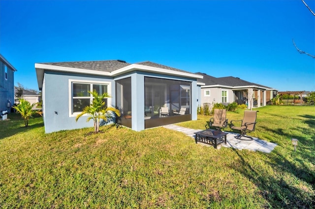 rear view of house with a fire pit, a sunroom, a yard, and a patio