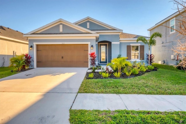 view of front facade featuring a front yard, concrete driveway, an attached garage, and stucco siding