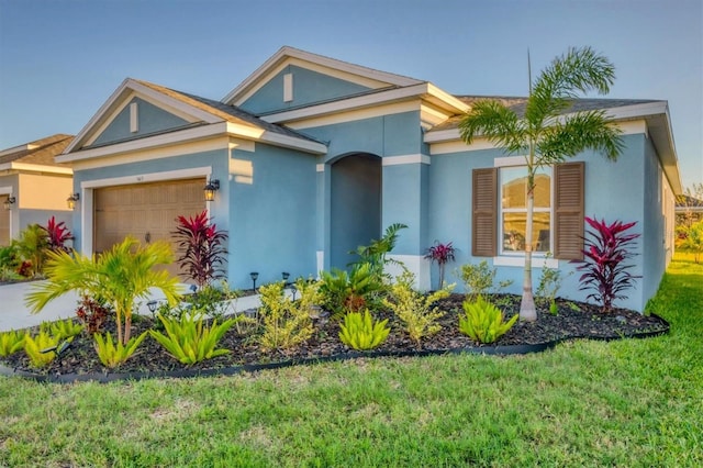 view of front facade featuring a garage, a front lawn, and stucco siding